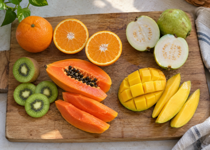 Cam, ổi, kiwi, đu đủ và xoài được sơ chế trên thớt gỗ